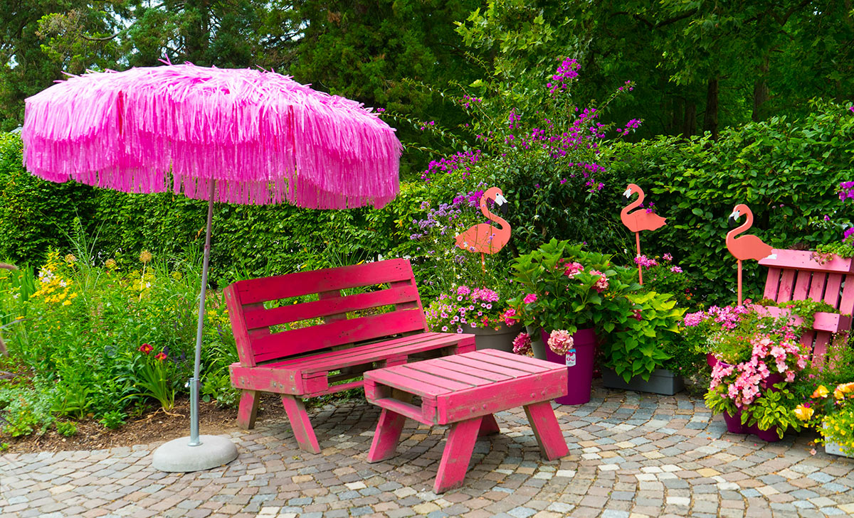 Panchina rosa da esterno con tavolino realizzato con i pallet.